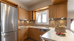 Une cuisine moderne avec des meubles en bois, des appareils électroménagers en acier inoxydable et un dosseret carrelé.