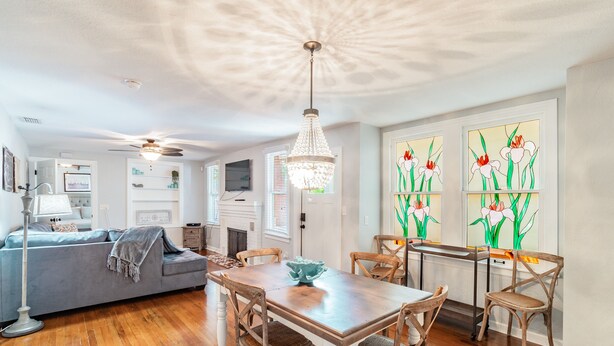A dining area with a wooden table, chairs, and a chandelier. - Downtown Dunedin B&B  Casa w/ Heated Pool (Dunedin)