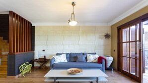 Un salon avec un canapé, une table basse et un escalier.