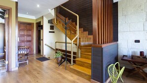 Un escalier avec des marches en bois et une rampe métallique, menant à l’étage supérieur.