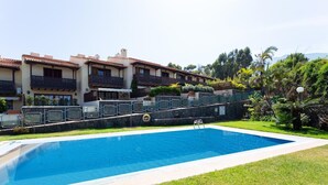 Une piscine avec un mur en pierre et une zone herbeuse devant.