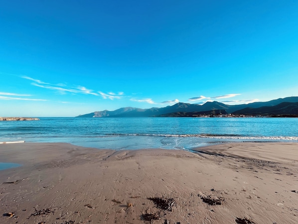 Una playa con vista despejada a las montañas al fondo.