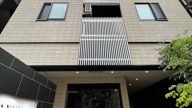 Un hotel moderno con una entrada destacada, ventanas amplias y un letrero que dice 'Hotel Erenoa'.