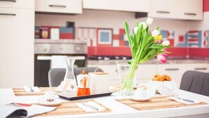 Ein Frühstückstisch mit einer Vase voller Tulpen, Croissants und einer Kaffeekanne.