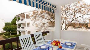 A balcony with a table set for four, white chairs, and a blue and white checkered tablecloth. - Nautic Golf Playa C II by Interhome (Pals)