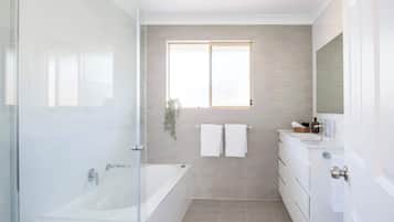 Bathtub, hair dryer, towels, shampoo
