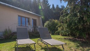 A building with a balcony and two sun loungers in the foreground. - La Maison Rocher - Fournels (FOURNELS)