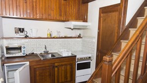 A compact kitchen with wooden cabinets, a built-in oven, a toaster, and a sink. - 3/4 pers rental in Grandviala (LA CHAZE-DE-PEYRE)