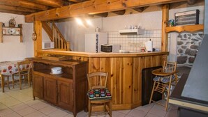 Eine rustikale Küche mit Holzbalken, einer Bar und einer Steinwand.