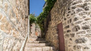 Una estrecha escalera de piedra en un edificio histórico con una puerta roja al final.