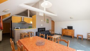 A compact living space with a dining area, kitchenette, and seating area.