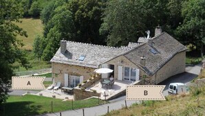 A stone house with a patio and a car parked nearby.
