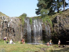 A natural waterfall with people enjoying the water. - Gîtes de France 11 people in Le Teil (ALBARET LE COMTAL)
