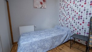 A small room with a single bed, a radiator, a chair, and a wall with a polka dot pattern. - Gîtes de France 11 people in Le Teil (ALBARET LE COMTAL)