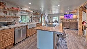 A modern kitchen with wooden cabinets, a dishwasher, and a central island with bar stools.