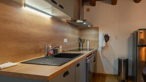 Una cocina moderna con encimera de madera, electrodomésticos de acero inoxidable y lavavajillas integrado.