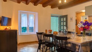 Un comedor con techo de madera, una mesa preparada para cuatro personas y un ventanal con vidrio esmerilado.