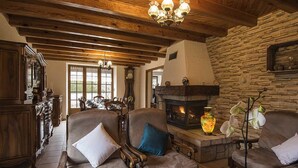 Un salon chaleureux avec une cheminée, des meubles en bois et un mur en pierre.