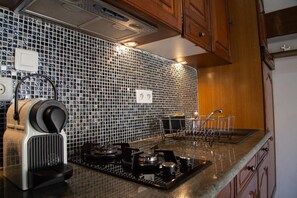 Een koelkast, een microgolfoven, een oven, kookgerei, borden en bestek