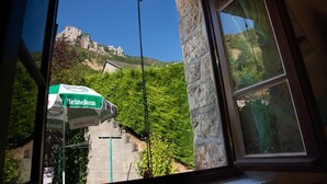 A window view of a stone building with a Heineken beer cooler outside.