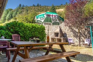 An outdoor dining area with a picnic table, chairs, and a Heineken-branded umbrella.