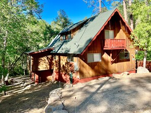Eine Holzhütte mit geneigtem Dach, einem Balkon und einem kleinen Fenster.