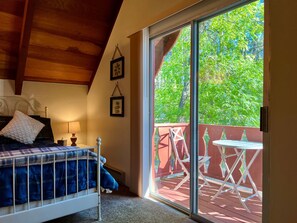 Ein Schlafzimmer mit einem Bett, Nachttisch, Lampe und zwei gerahmten Bildern an der Wand.