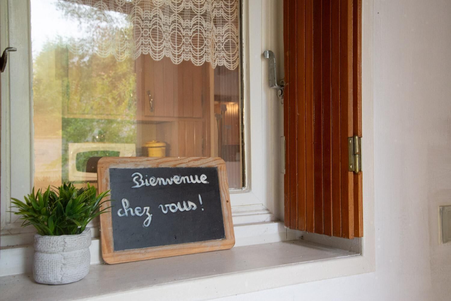 Eine Tafel mit der Aufschrift 'Bienvenue chez vous!' vor einer Tür.