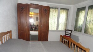 Un dormitorio con una cama grande, un armario de madera y una silla.