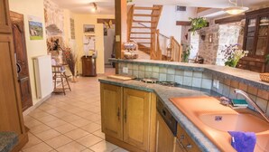 Una cocina con armarios de madera, un fregadero de cobre y un salpicadero azulejado.