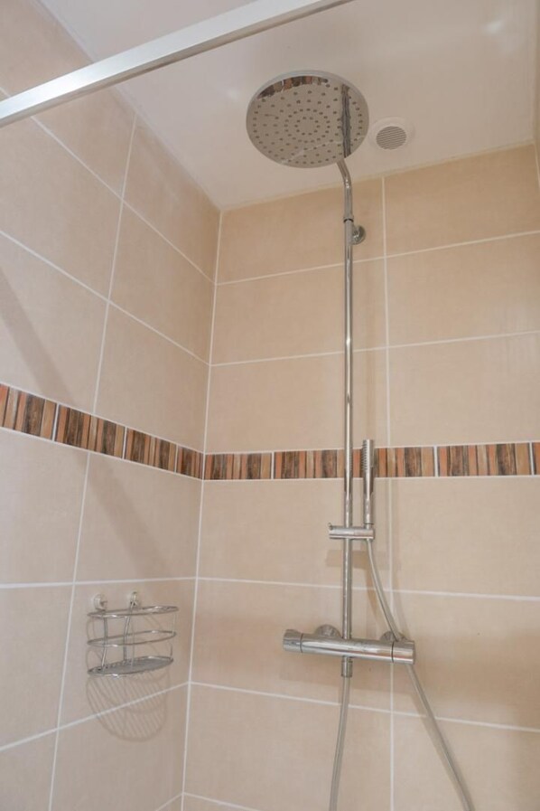A shower with a handheld showerhead, a wall-mounted towel rack, and a corner tile design. - L'Ecole d'Antan 5/6 people (CHANAC)