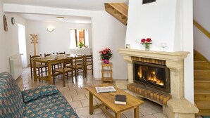 Un salon avec une cheminée, des meubles en bois et un escalier.