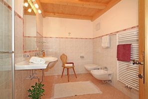 Une salle de bain équipée d’une douche, d’un lavabo, de toilettes et d’un radiateur.