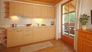 Una cucina con mobili in legno, un piano di lavoro e una finestra con tende.