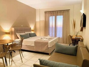 Um quarto com cama, sofá, mesa de jantar e cadeiras.