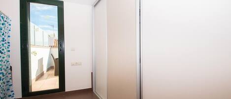 A hallway with a sliding door leading to an outdoor balcony.
