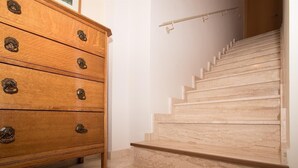 A wooden dresser with multiple drawers and a marble staircase.