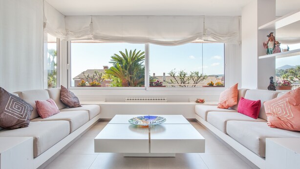 A modern living room with a sofa set, a coffee table, and a view of a residential area. - Villa 'Berganti' with Private Pool, Wi-Fi, and Air Conditioning (Canet de Mar)