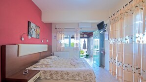 Un dormitorio con cama, mesita de noche y televisión montada en la pared.