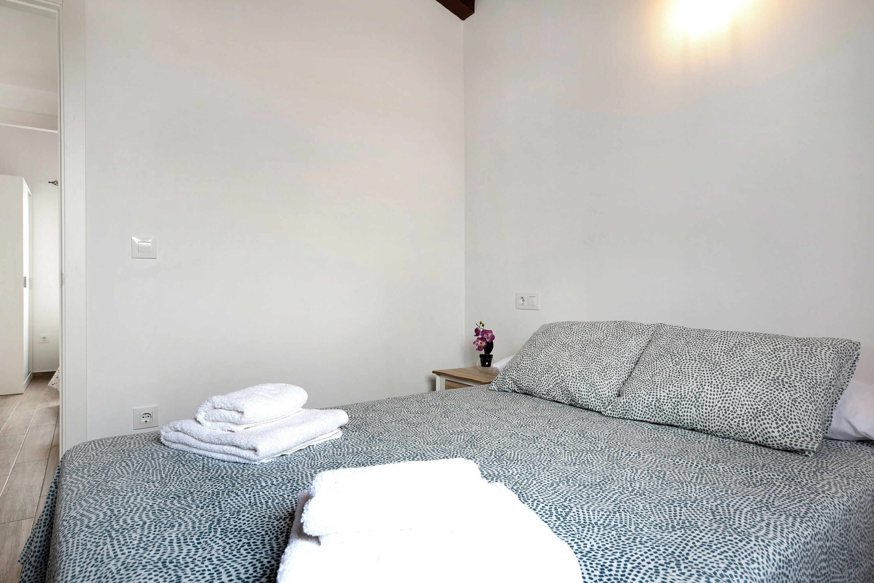 Ein Schlafzimmer mit Bett, Nachttisch und einer Steckdose.