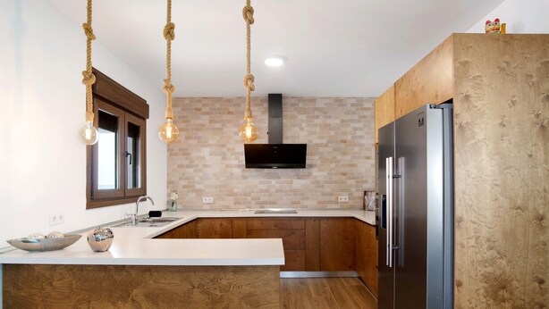 A modern kitchen with a central island, wooden cabinets, a stainless steel refrigerator, and pendant lights. - Holiday Home 'Casa La Teja 2' with Pool and Wi-Fi (Vejer de la frontera)