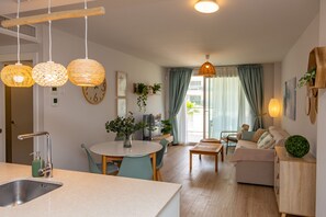 Cozy living space with a dining area, sofa, and large window offering a view of the outdoors.