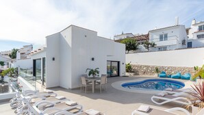 A rooftop terrace with a swimming pool, lounge chairs, and a small table with chairs. - Luxury Villa with Private Pool, with Sea View, Wi-Fi and Air Conditioning (La Cala de Mijas)