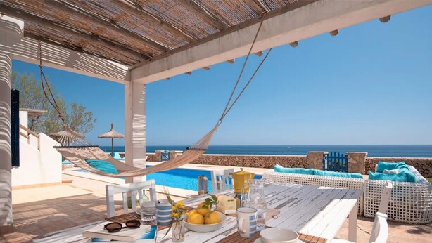 A terrace with a pool, outdoor seating, and a view of the sea. - Holiday Home Villa Domus Alba B with Sea View, Pool, Garden & Wi-Fi (portocolom)