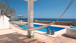 A hammock, a pool, and a view of the sea. - Holiday Home Villa Domus Alba B with Sea View, Pool, Garden & Wi-Fi (portocolom)