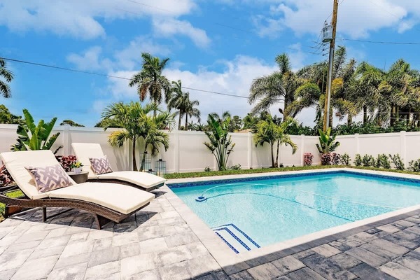 Come take a dip in the private, professionally maintained pool and enjoy the luxe chaise lounge chairs. | Coastal Sol by Boutiq Luxury Vacation Rentals | Naples, Florida