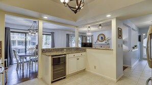 A modern kitchen with a central island, built-in appliances, and a dining area with a view.