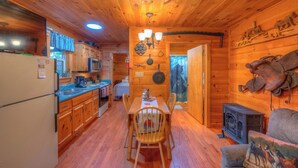 A wooden cabin interior with a kitchen, dining area, and a fireplace. - ☆Augst Week Day Openings☆ 
 (Murphy)
