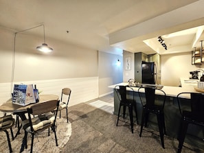 A compact kitchen with a dining area, a refrigerator, and a small island.