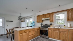 Una cucina moderna con mobili in legno, un'isola centrale e un forno integrato.